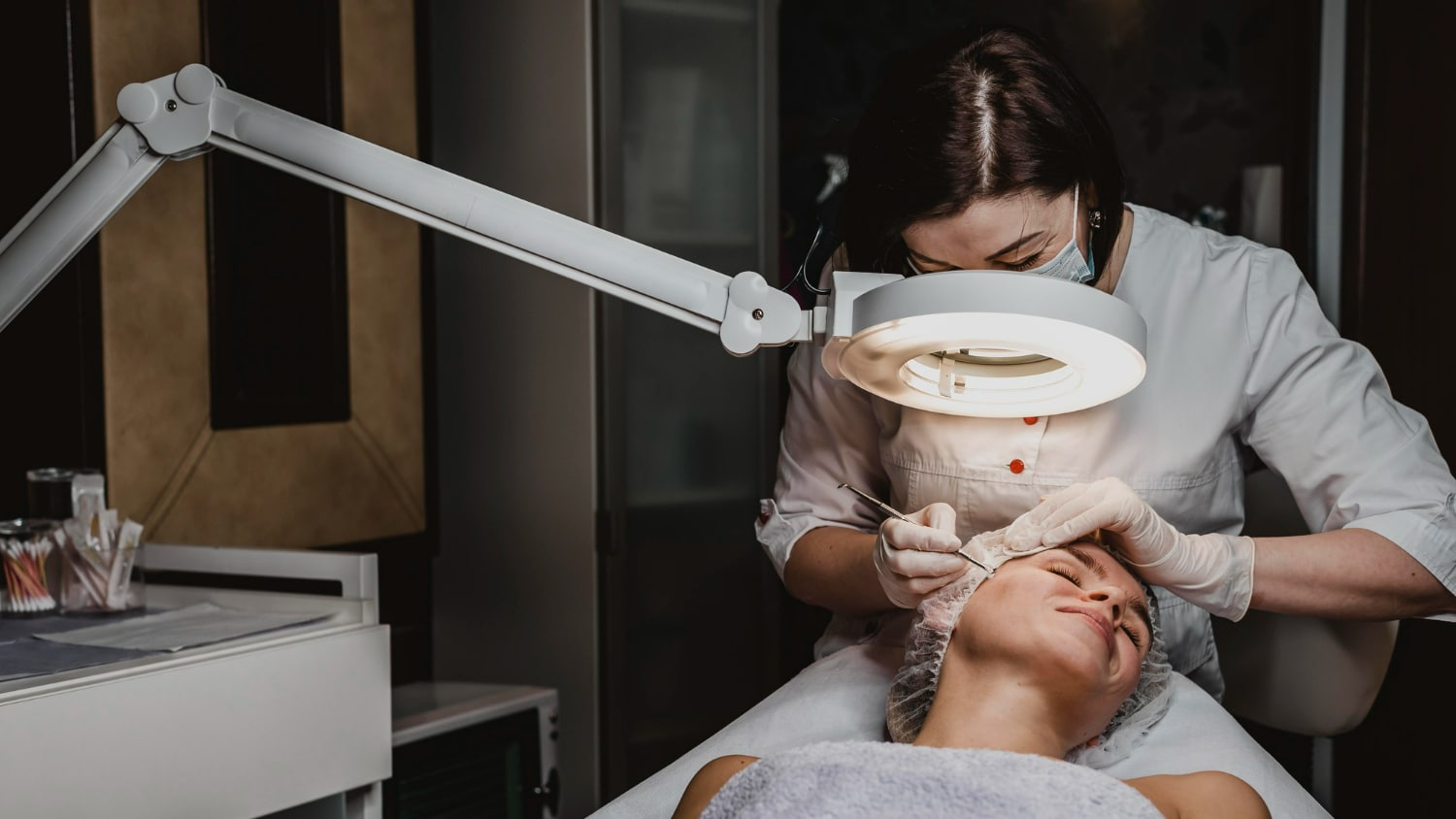 profissional de estética realizando procedimento no rosto de uma paciente