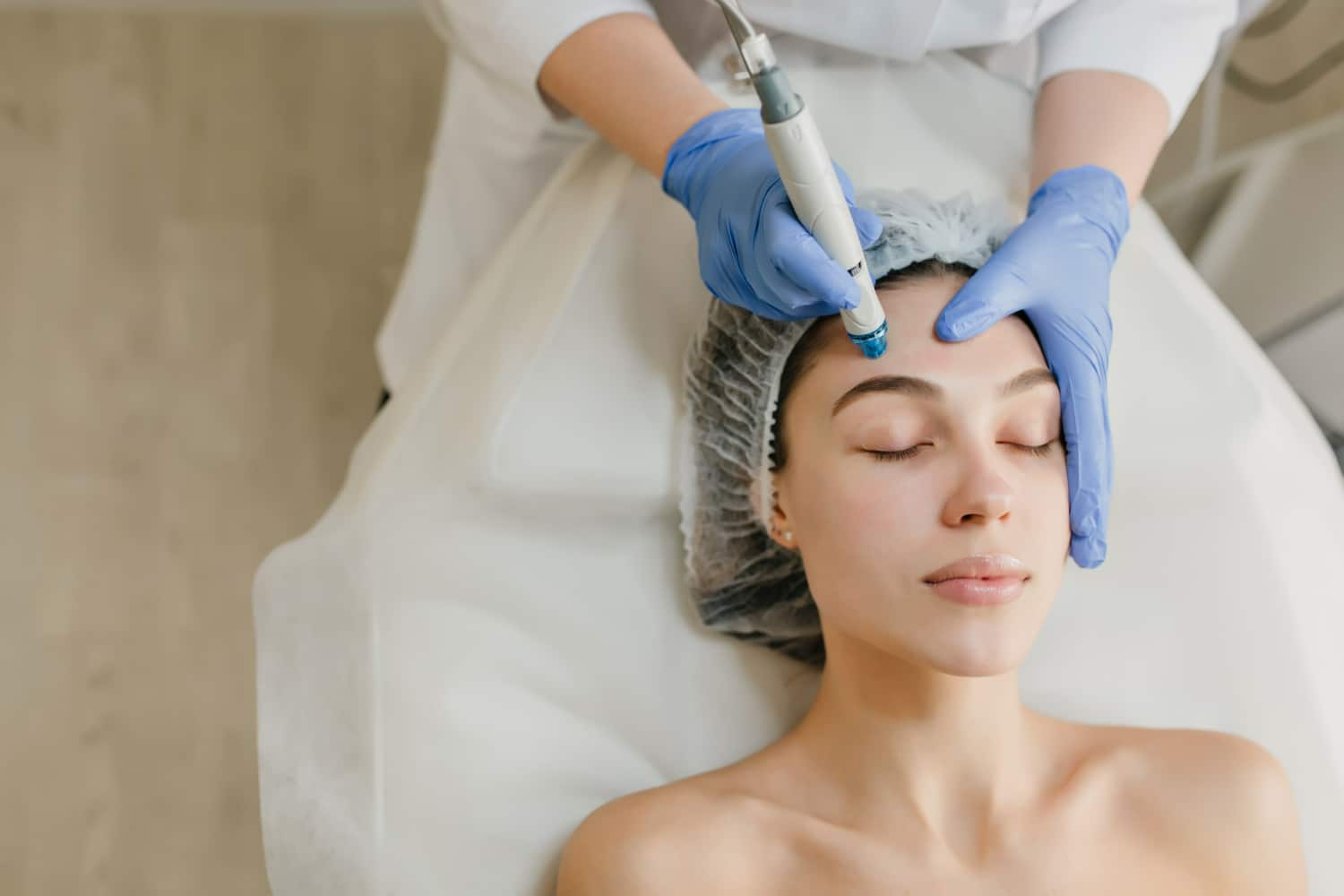 profissional de estética realizando procedimento com um equipamento na face de um paciente