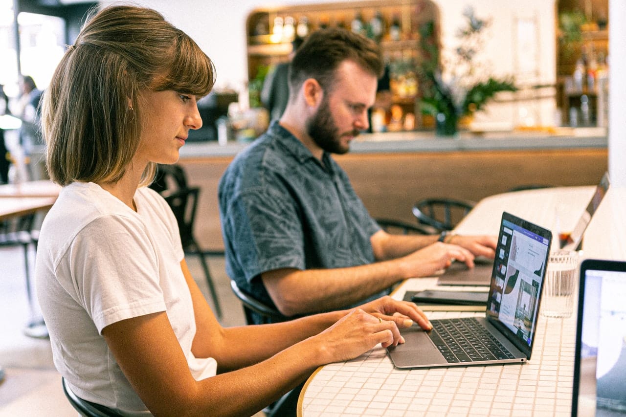 homem e uma mulher sentado em frente a um computador