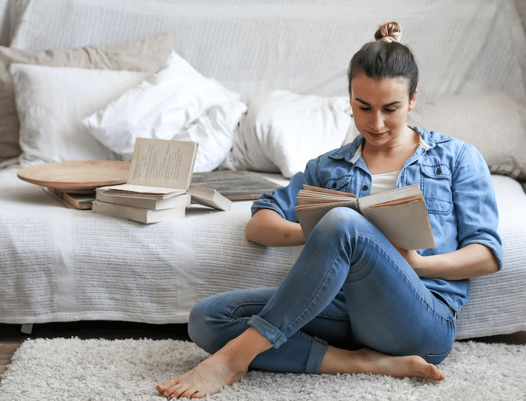 mulher sentada no chão lendo um livro