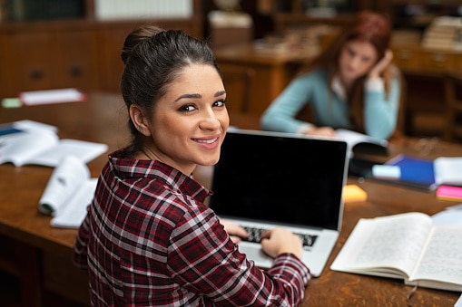 mulher sentada a mesa com um computador