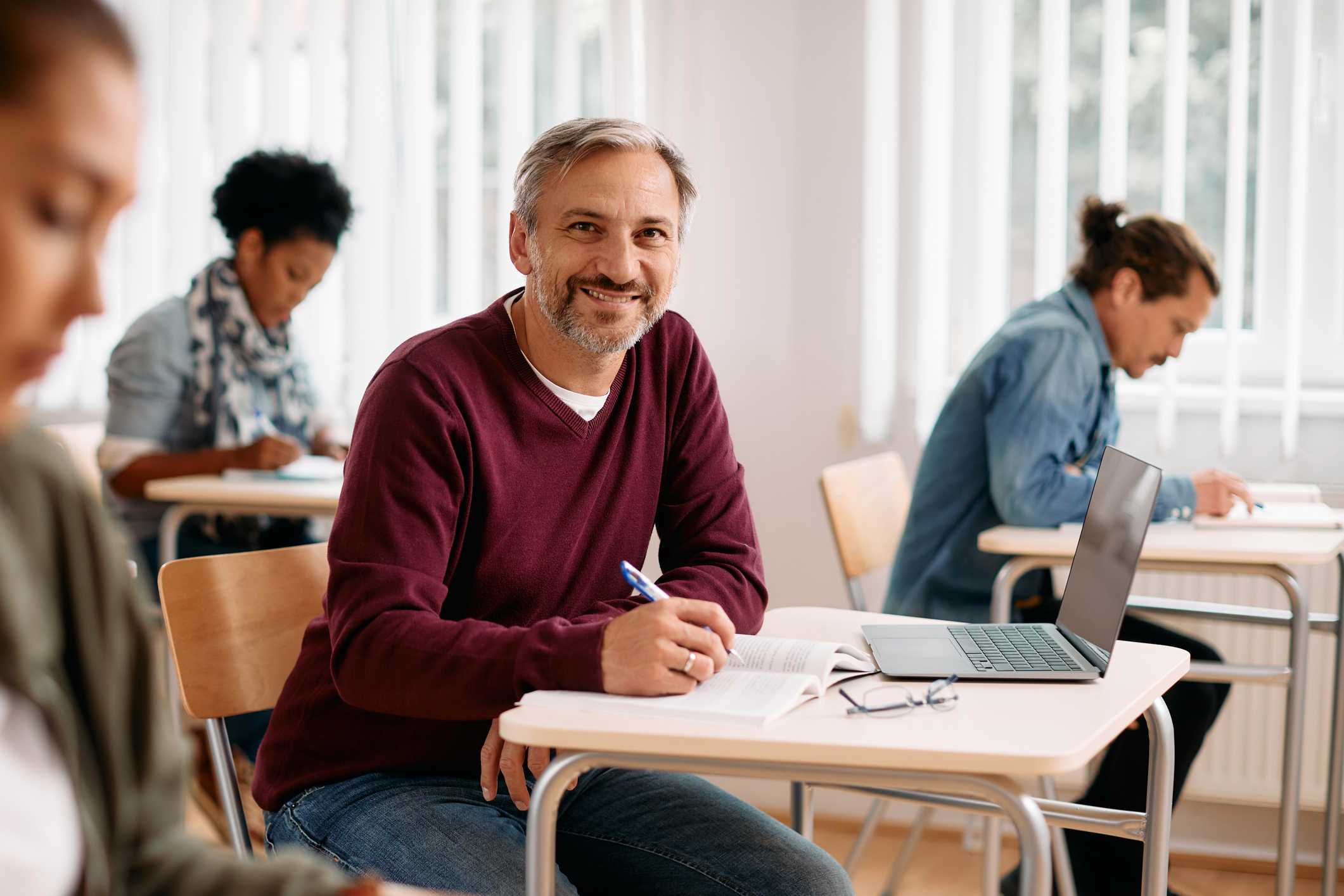 homem sentado a mesa em frente um notebook